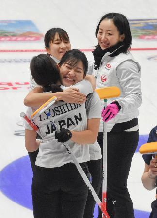 　女子１次リーグで韓国に勝利し、吉田夕（手前）と抱き合って喜ぶロコ・ソラーレの吉田知。奥左は鈴木、同右は藤沢＝レーワルデン（共同）