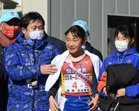 仙台育英・釜石慶太監督（左）は、仙台育英・須郷柚菜（中央）にタオルを掛ける＝たけびしスタジアム京都（撮影・山口登）