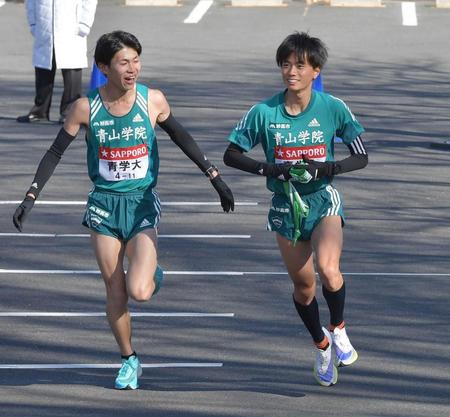 　青学大４区・飯田貴之（左）から襷を受け取り走り出す５区・若林宏樹（撮影・佐々木彰尚）