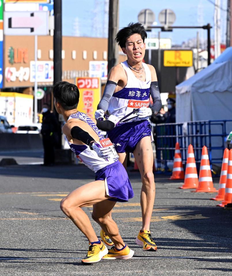 　２区の駒大・田沢が３区の安原（左）にたすきをつなぐ（撮影・堀内翔）