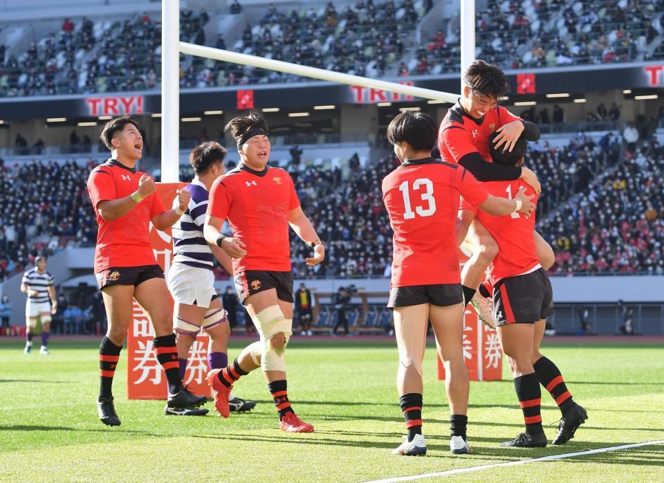 　前半終了前、３つ目のトライを決めた白国亮大（右）を祝福する帝京大フィフティーン（撮影・西岡正）