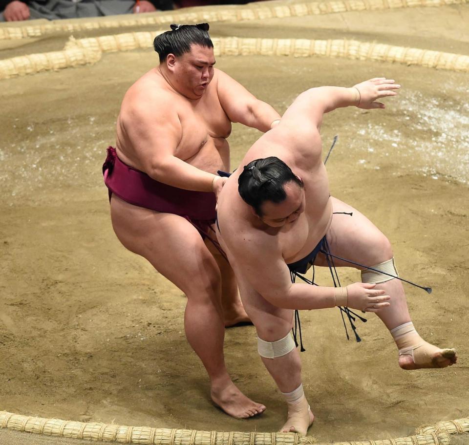 　御嶽海（左）が送り出しで宝富士を下す（撮影・中島達哉）