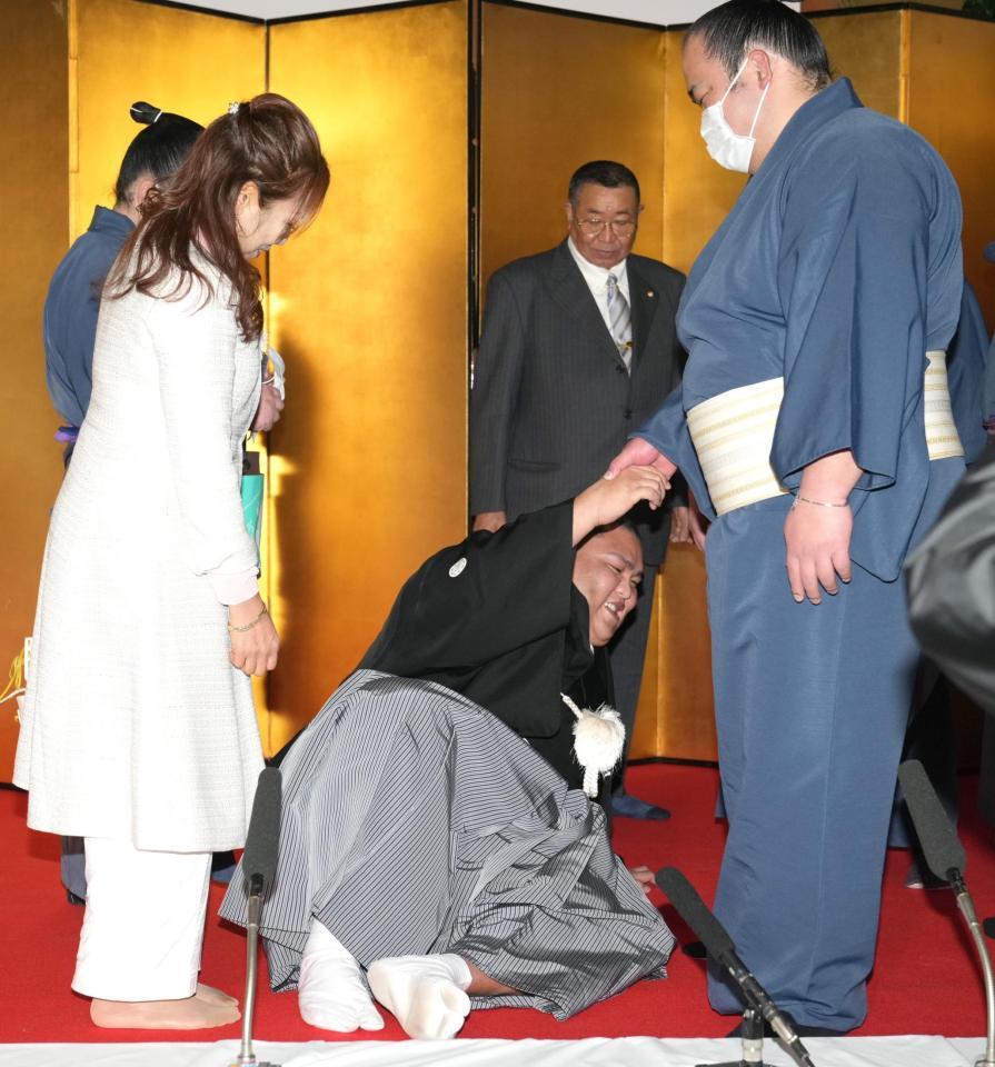 会見後、立ち上がれない御嶽海（中央手前）とその様子を見つめる母・大道マルガリータさん（左）と父・大道春男さん（中央奥）＝代表撮影