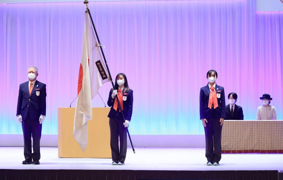 　北京冬季オリンピックの日本選手団の結団式で、秋篠宮さまご夫妻が見守る中、団旗を伊東団長（左）から受け取った郷亜里砂旗手（左から２人目）。同３人目は高木美帆主将（代表撮影）