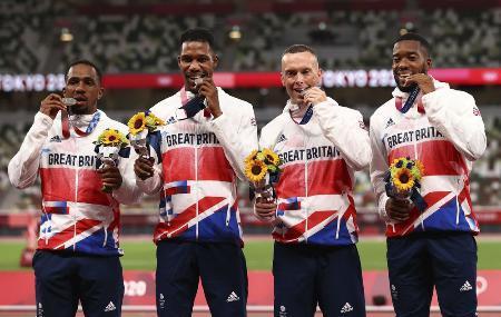 　陸上男子４００メートルリレーの銀メダルを手にポーズをとる英国のチジンドゥ・ウジャ（左端）ら＝２０２１年８月、国立競技場（ロイター＝共同）