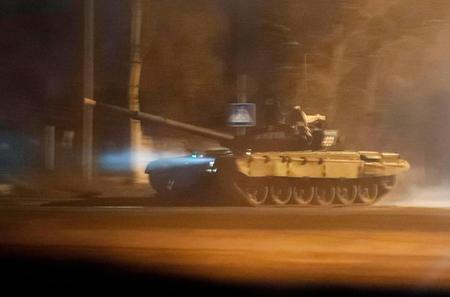 　22日、親ロ派が支配するウクライナ東部のドネツクで通りを走行する戦車（ロイター＝共同）