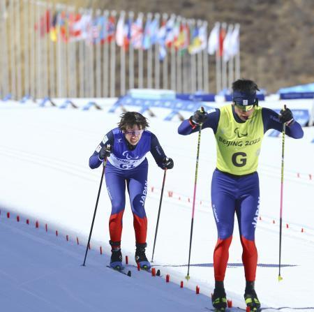 　男子２０キロクラシカル視覚障害　ゴールに向かう有安諒平。右手前はガイドスキーヤーの藤田佑平さん＝張家口（共同）