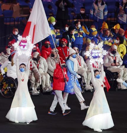 　北京冬季パラリンピックの閉会式で、日の丸を掲げて入場する旗手の川除大輝（中央）＝１３日、北京（共同）