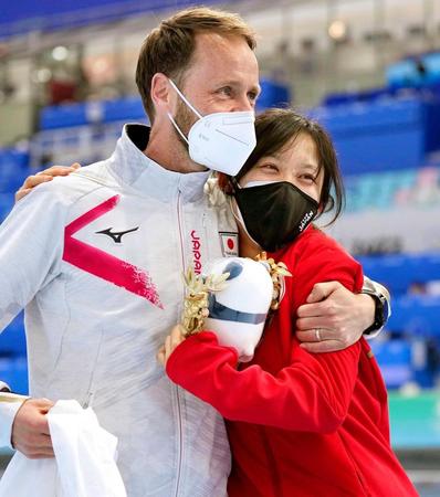 　北京五輪のスピードスケート女子１０００メートルで金メダルを獲得した高木美帆（右）と抱き合うヨハン・デビット・コーチ（共同）
