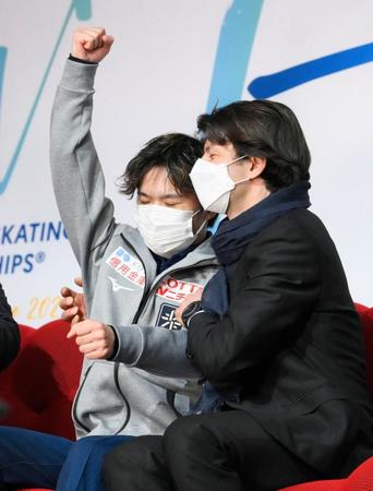 　初優勝し、ガッツポーズする宇野昌磨。右はステファン・ランビエル・コーチ（共同）