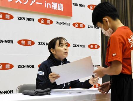 　交流イベントで子供たちにサインを書いて手渡す石川佳純（左）
