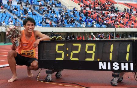 　５分２９秒１１の日本新記録を打ち立て、時計の前でポーズをとる楠康成