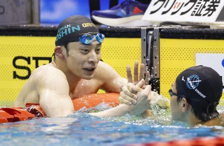 　男子１００メートル背泳ぎで優勝し、９連覇を果たした入江陵介（左）＝横浜国際プール