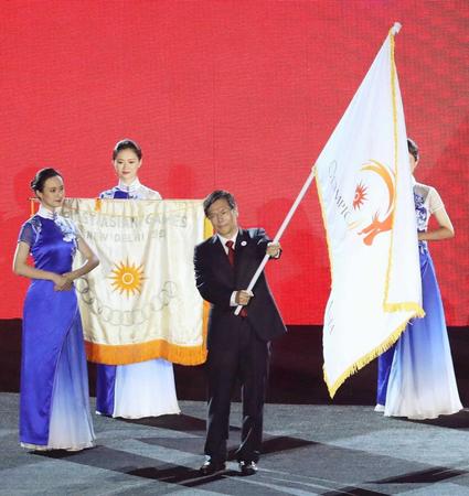 　２０１８年９月、ジャカルタ・アジア大会の閉会式で、引き継がれた大会旗を振る中国・杭州の関係者（共同）