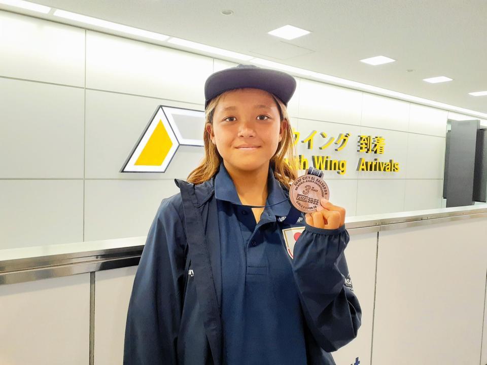 世界ジュニア選手権１６歳以下の部で３位になり、銅メダルを掲げる池田美来＝成田空港