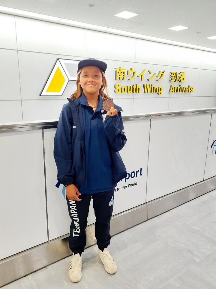 世界ジュニア選手権１６歳以下の部で３位になり、銅メダルを掲げる池田美来＝成田空港