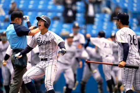 　明大-仏教大　タイブレークの延長１０回、相手の失策でサヨナラの生還を果たし、喜ぶ仏教大の二走七條（左）＝神宮