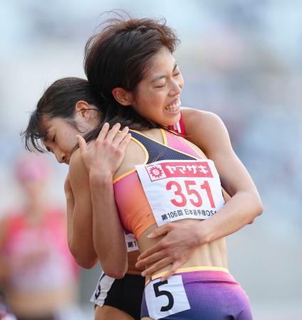 　女子５０００メートルのレースを終え、抱き合う１位の田中希実（手前）と２位の広中璃梨佳＝ヤンマースタジアム長居