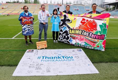　「釜石ラグビー応援団」がウルグアイ代表に贈った大漁旗。右から２人目は石山次郎さん＝１７日、秩父宮ラグビー場