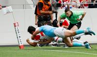 　日本－ウルグアイ　前半、タックルを受けながら先制トライを決める坂手（奥）＝ミクニワールドスタジアム北九州