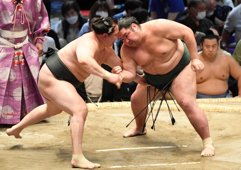 　千代翔馬（左）を押し出しで破り、２敗を守った錦木（撮影・佐藤厚）