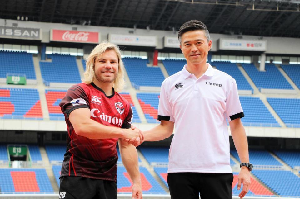 　入団会見後に握手するデクラークと沢木監督（右）＝日産スタジアム