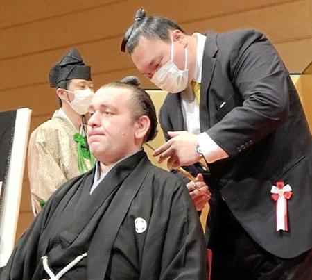 　元横綱白鵬の宮城野親方（右）にはさみを入れられる元小結臥牙丸