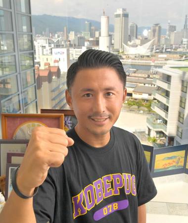 　神戸の街並みを背にポーズを決める大塚聡氏（撮影・吉澤敬太）