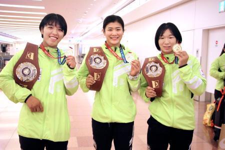 　レスリングのＵ２０世界選手権から帰国し、取材に応じる（左から）石井亜海、尾崎野乃香、元木咲良＝２１日午後、羽田空港