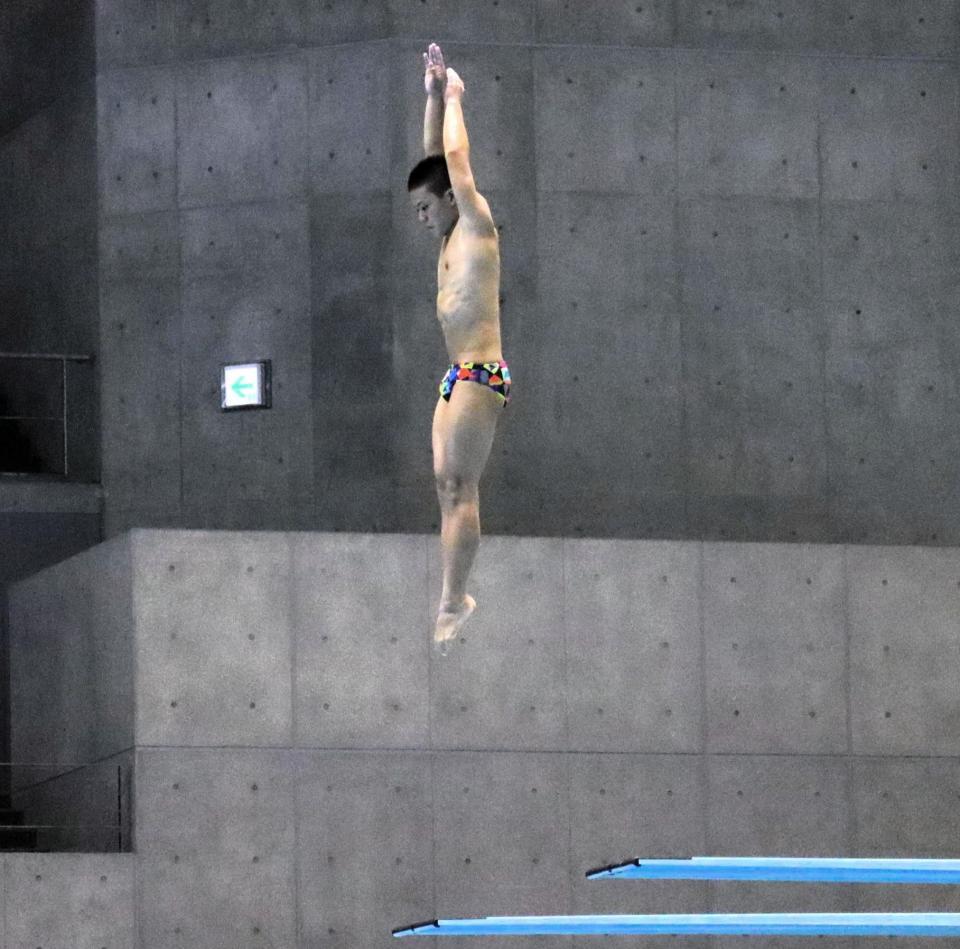 少年男子板飛び込みで演技を行う伊熊