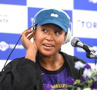 　会見の前にヘッドホンを外して笑顔を見せる大坂なおみ