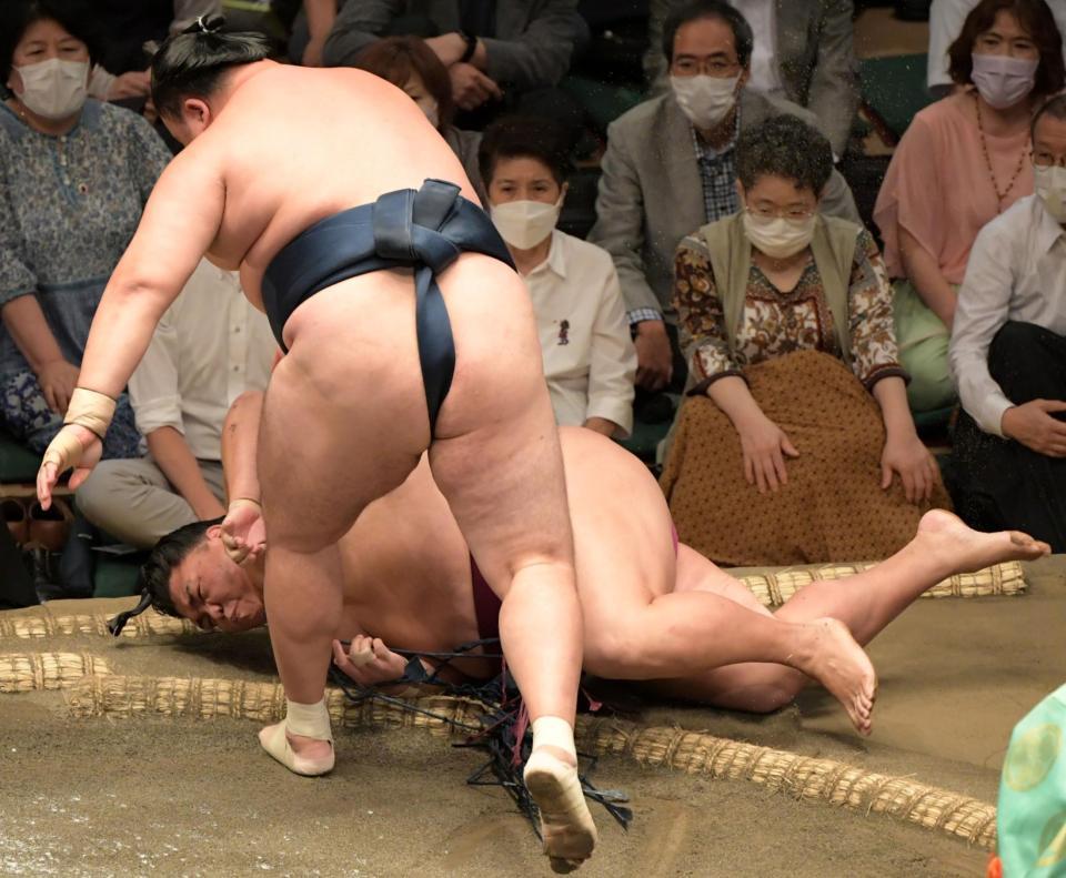 　玉鷲にすくい投げで敗れた御嶽海（奥）＝撮影・三好信也