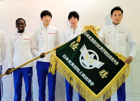 　再作成された優勝旗を持つ（右から）小川智監督、主将の設楽悠太