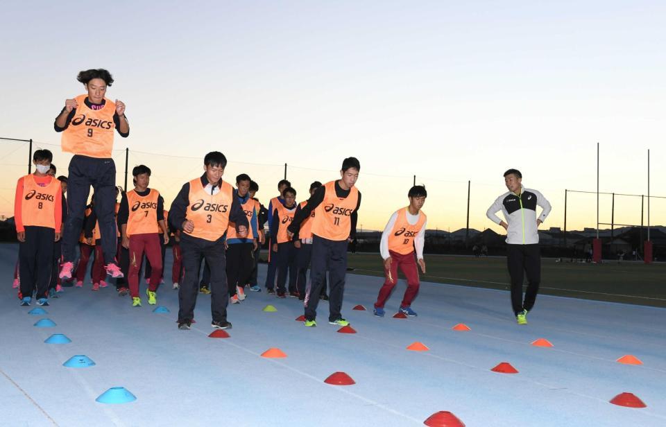 　陸上競技部の生徒を指導する桐生（右）