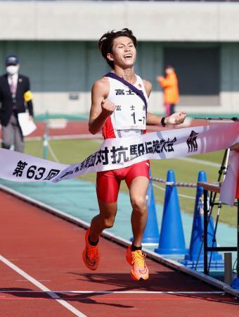 　優勝を決め、ガッツポーズでゴールする富士通のアンカー・飯田貴之＝熊谷スポーツ文化公園陸上競技場