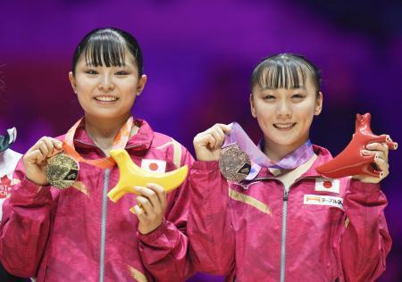 　体操の世界選手権の女子平均台で獲得した金メダルを手にする渡部葉月（左）と銅メダルの宮田笙子＝６日、英リバプール（共同）