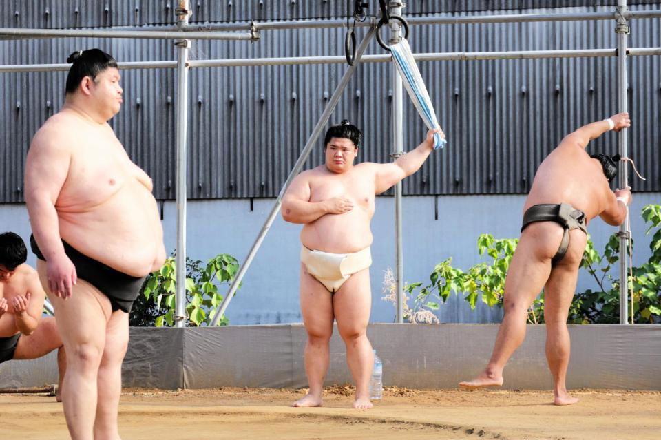 　吊り輪にかけたタオルで肩のストレッチを行う宇良（右から２人目）