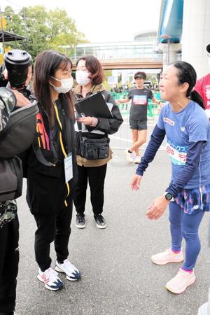 　９３回目のマラソン完走を遂げ、大会ゲストの田中希実（手前左）に迎えられる母千洋さん（右端）