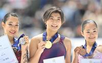 　２位の三原舞依（左）、３位の島田麻央（右）と共に記念写真に納まる坂本花織（撮影・高部洋祐）