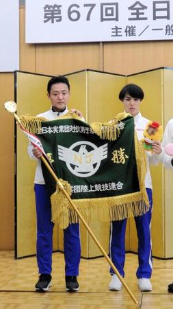 　優勝旗を持ち、記念写真を撮るホンダの監督と選手＝群馬県庁