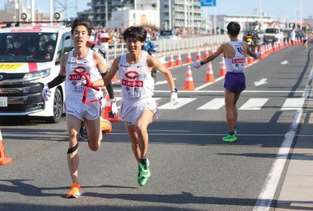 　トップでタスキをつなぐ３区の中大・中野翔太（左）と４区・吉居駿恭（代表撮影）