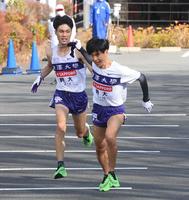 　５区、駒大・鈴木芽吹（左）が山川拓馬にタスキを渡す（撮影・堀内翔）