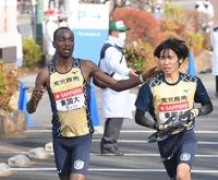 　タスキを渡す東京国際大・ビンセント。右は川端拳史（撮影・堀内翔）