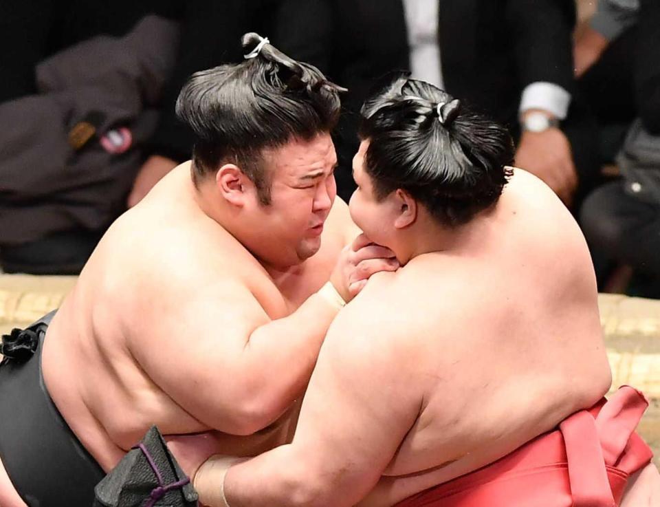 　立ち合いで阿武咲（右）と激しくぶつかりにらみ合う貴景勝＝両国国技館（撮影・開出牧）
