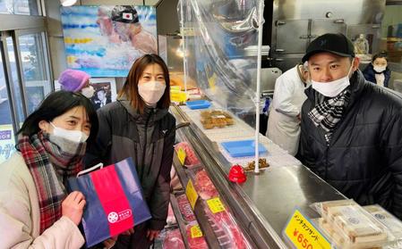 　実家の精肉店を手伝う北島康介さん（右）と購入に訪れた（左から）中村礼子さん、寺川綾さん