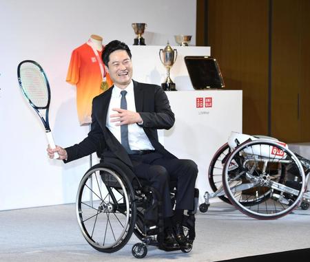 　引退会見を終え、笑顔でテニスラケットを振る国枝（撮影・棚橋慶太）