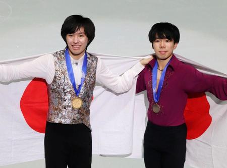 　日の丸を広げる、男子で史上最年少優勝の三浦佳生（左）と３位に入った佐藤駿