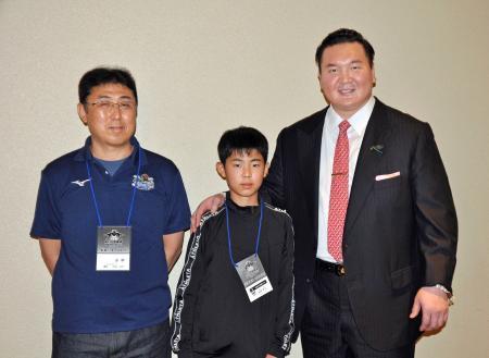 　宮城野親方（右）と写真に納まる、岩手県山田町から参加した佐藤真士君（中央）と父哲也さん＝１２日、両国国技館