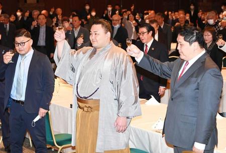　地元・富山での激励会で乾杯する朝乃山。右は高砂親方、左は若松親方