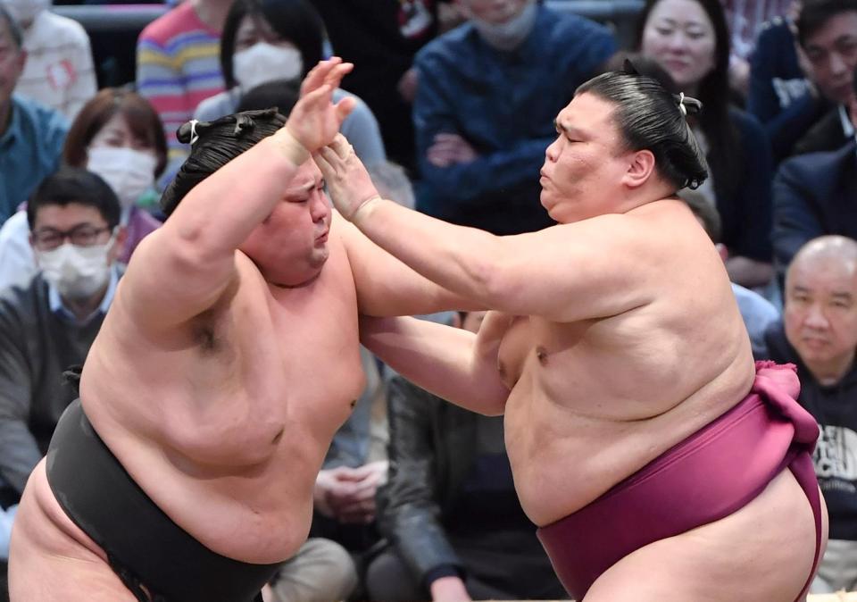 　御嶽海（右）と攻め合う貴景勝。押し出しで破れる